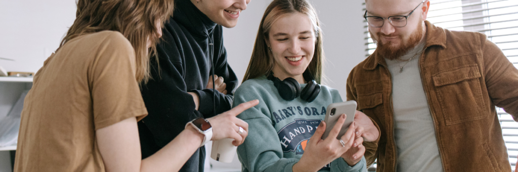 group viewing mobile phone interacting