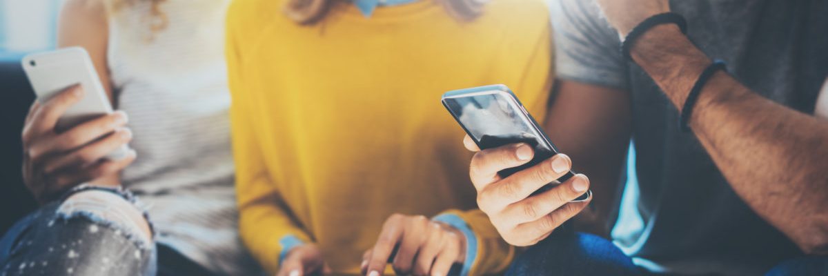 closeup-group-addult-hipsters- looking at phones_shutterstock_482236333